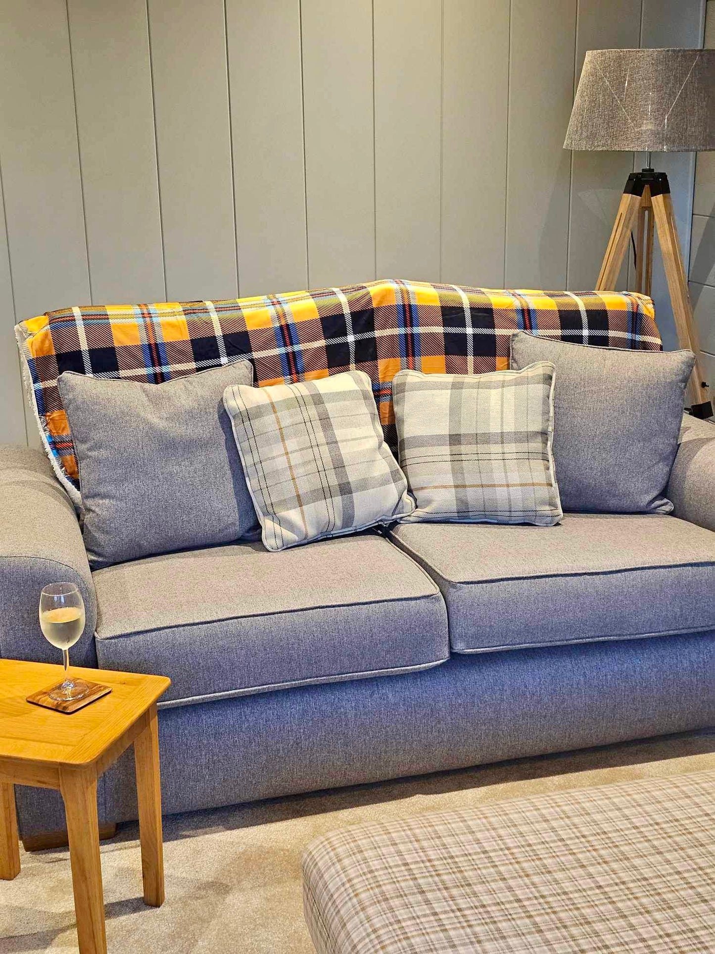 Yellow Cornish Tartan Dog Blanket laid across the back of a grey sofa
